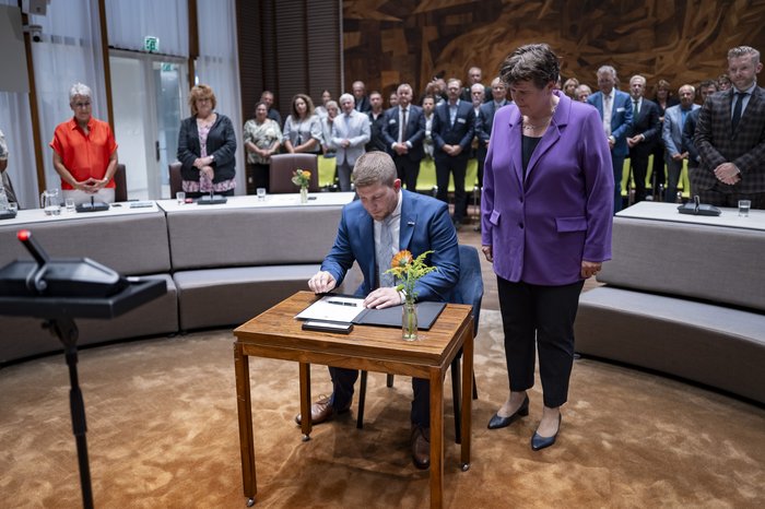 Burgemeester Davy Jansen zet zijn handtekening in het bijzijn van de Commissaris van de Koning van Noord-Brabant, Ine Adema.